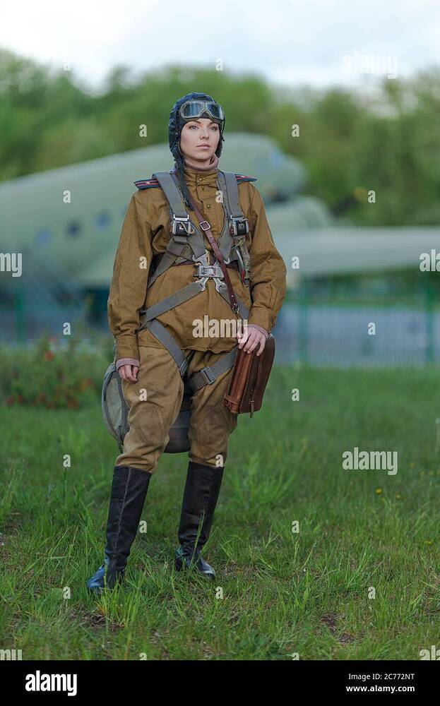 a-young-female-pilot-in-uniform-of-soviet-army-pilots-during-the-world-war-ii-military-shirt-with-shoulder-straps-of-a-major-parachute-flight-helme-2C772NT