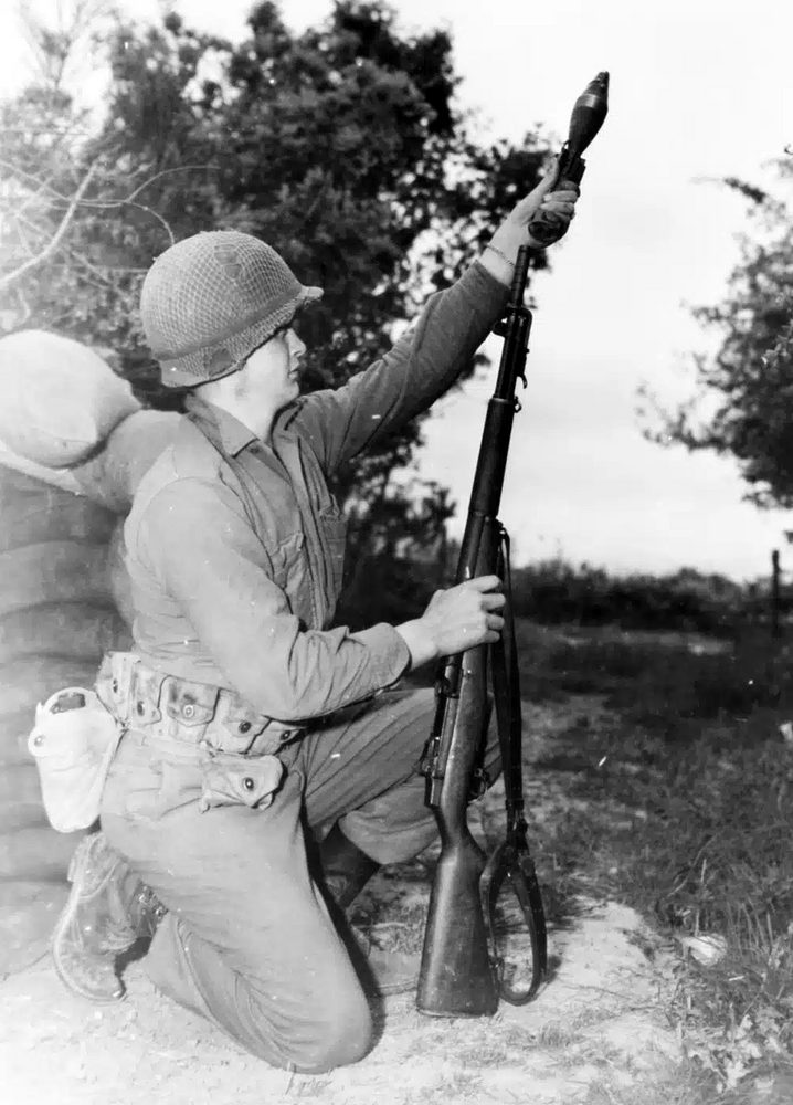 101st-Airborne-Division-soldier-loads-60mm-round-on-grenade-launching-adaptor-1945.jpg