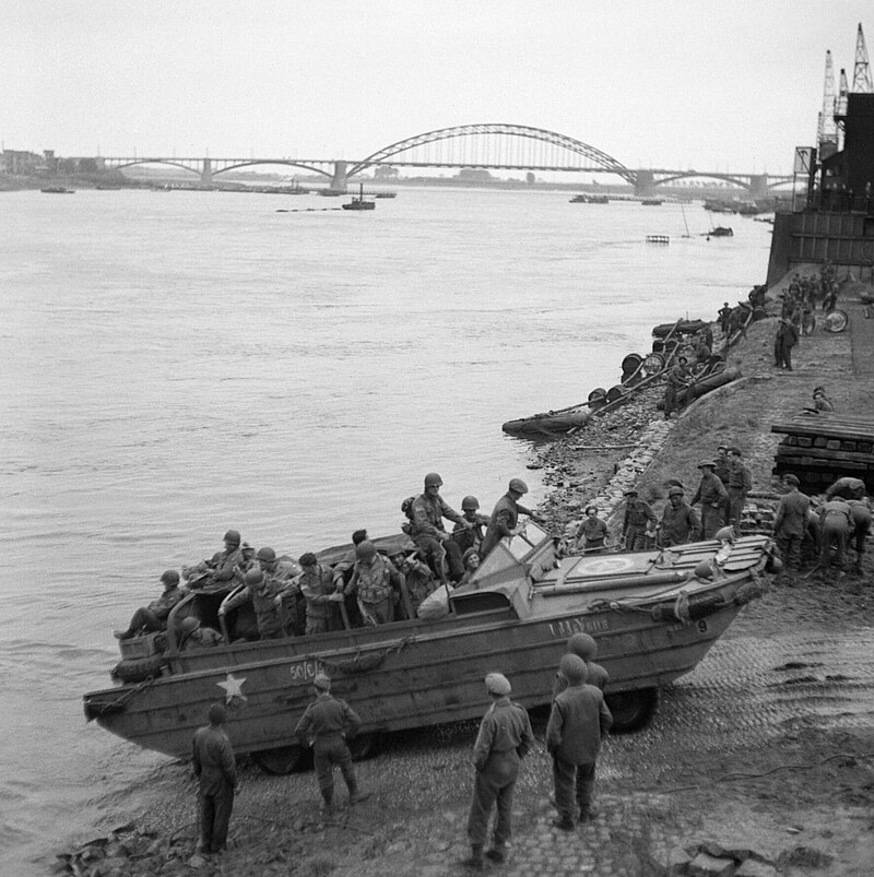 A_British_DUKW_carries_supplies_and_American_paratroopers_across_the_Waal_river_at_Nijmegen,_30_September_1944._B10434